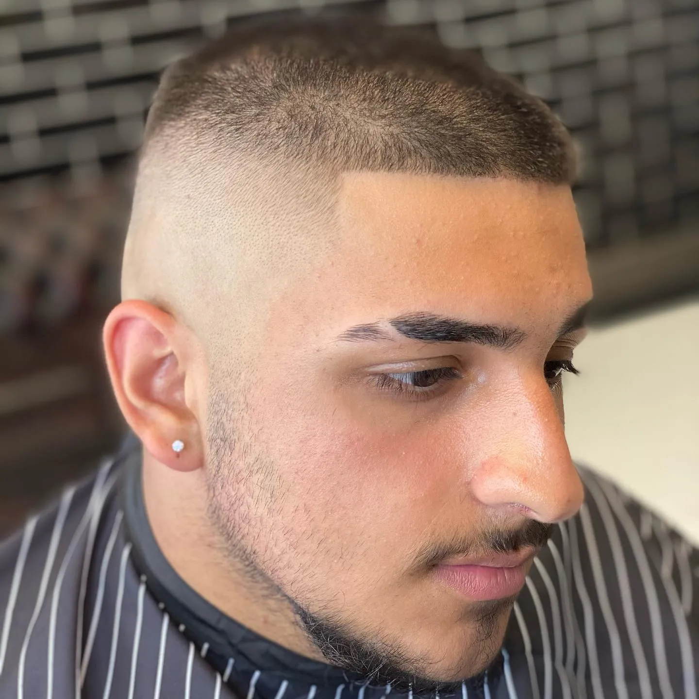 High skin fade with a short crop on top, three-quarter view